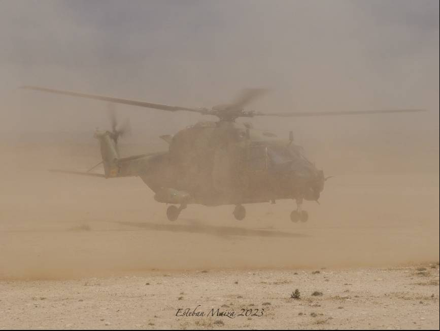UN NH-90 del BHELMA III envuelto en una nube de polvo mientras despega.